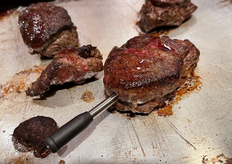 Yummly Smart Thermometer monitoring cooking steak