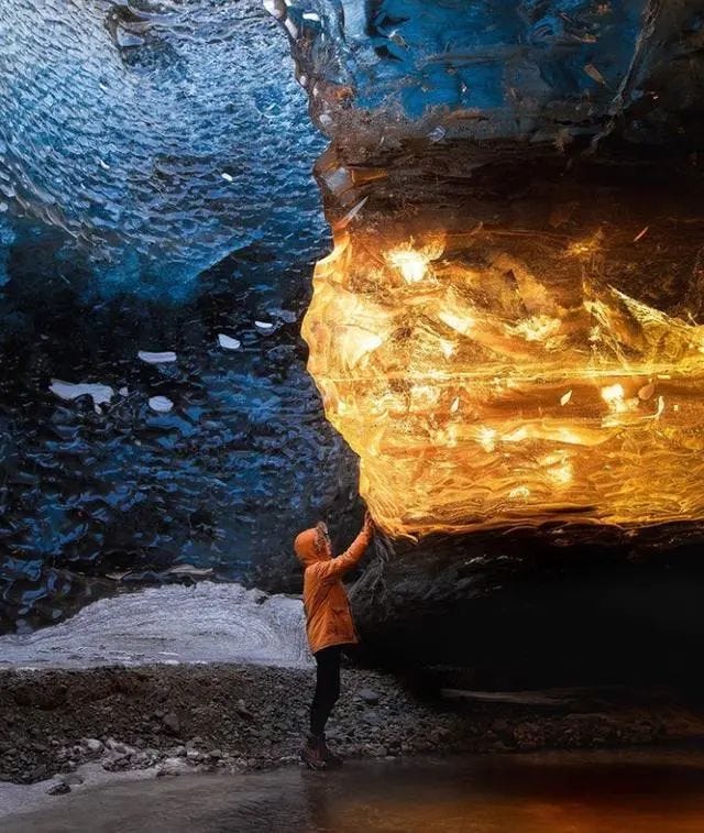 An amber-hued glacier cave in Iceland